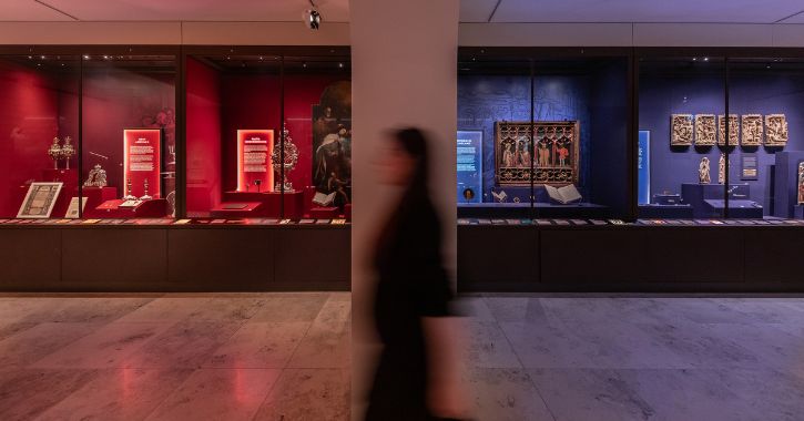 woman walking through the colourful blue and red galleries found within the Faith Museum, Bishop Auckland, County Durham